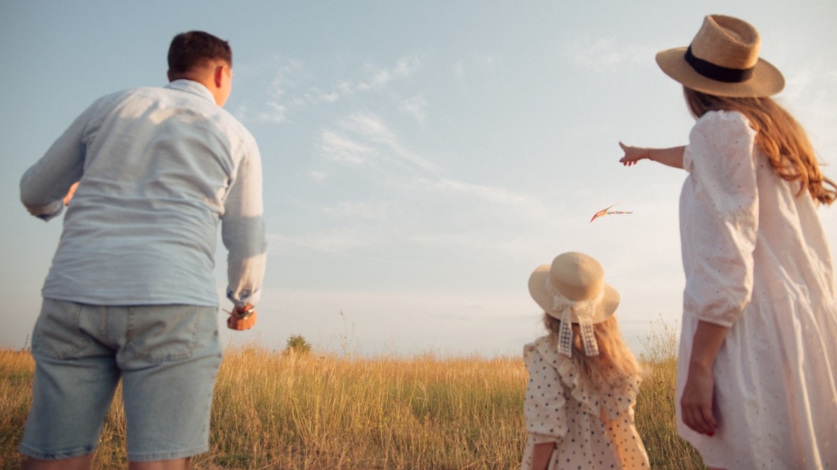 man in white dress shirt and woman in brown dress standing on green grass field during